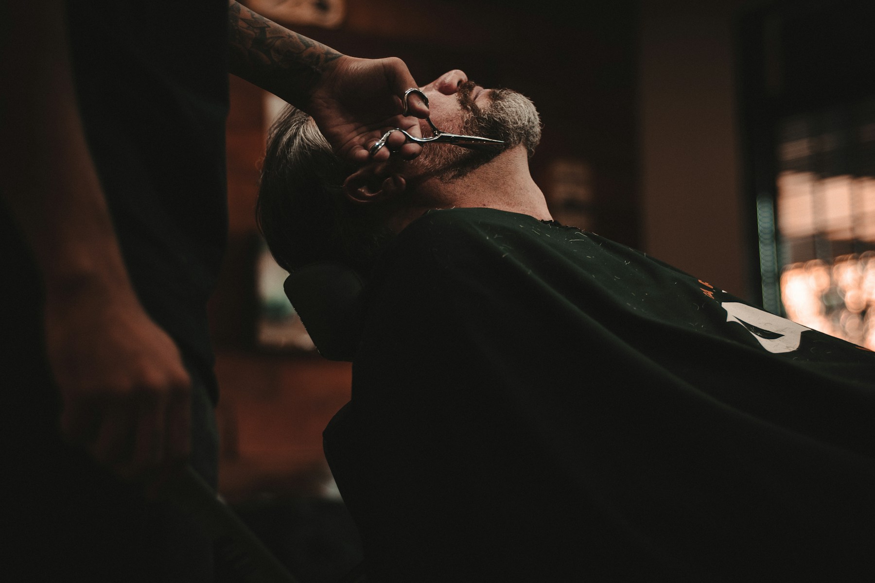 آرایشگر در حال اصلاح ریش مشتری